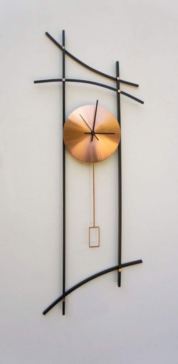 A modern wall clock with a minimalist design, featuring a golden circular face, black hands, and an artistic black metal frame with curved and straight elements.