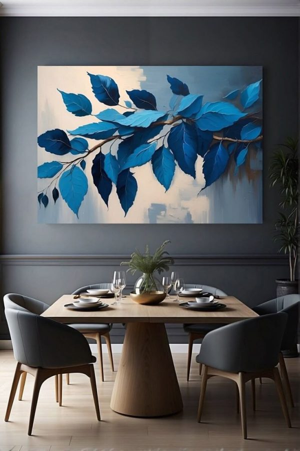 A modern dining room with a large oil painting of blue leaves on a branch, set against a textured abstract background. The space features a wooden dining table, elegant chairs, and stylish table settings.