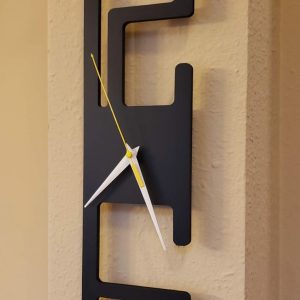 Vertical modern wall clock with artistic numbers and yellow-white hands