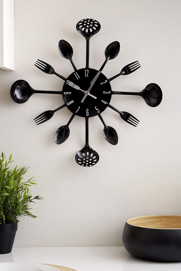 A unique black wall clock made from kitchen utensils such as forks, spoons, and ladles.